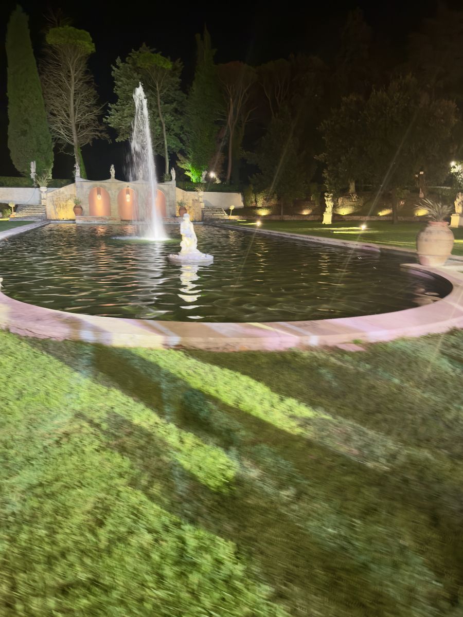 Beleuchteter Brunnen im Park der Villa des Vergers bei Nacht